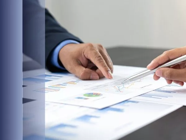 Hände zeigen auf Diagramme und Berichte